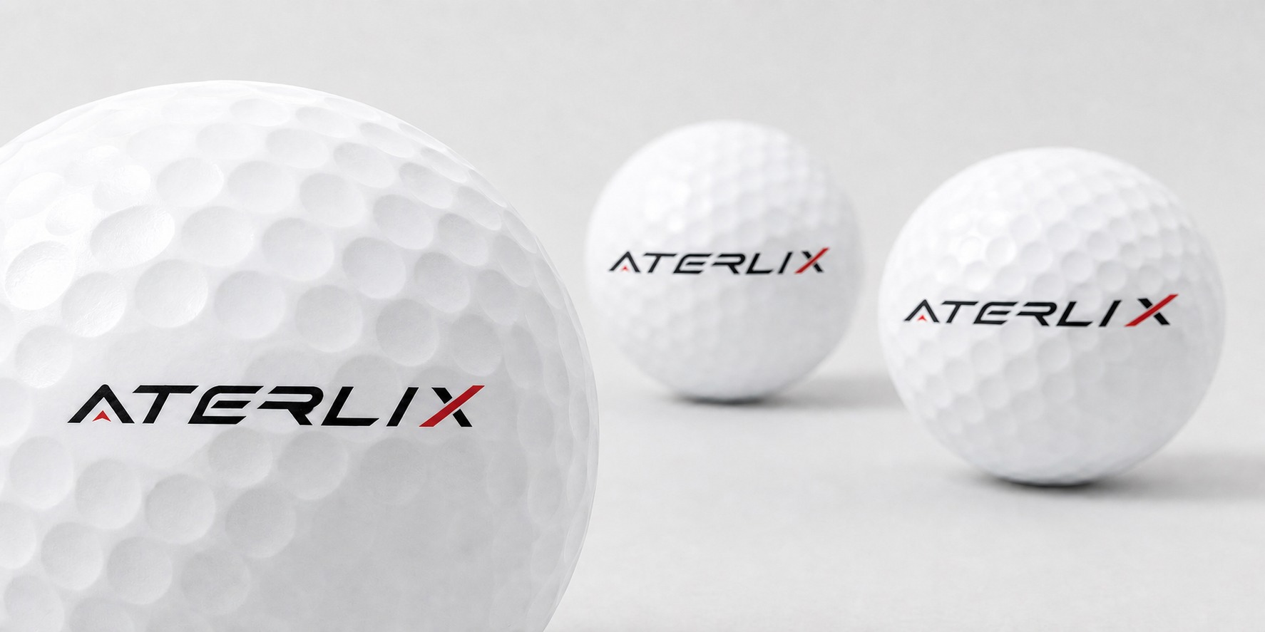 White ATERLIX Tour golf balls in a clean studio setting